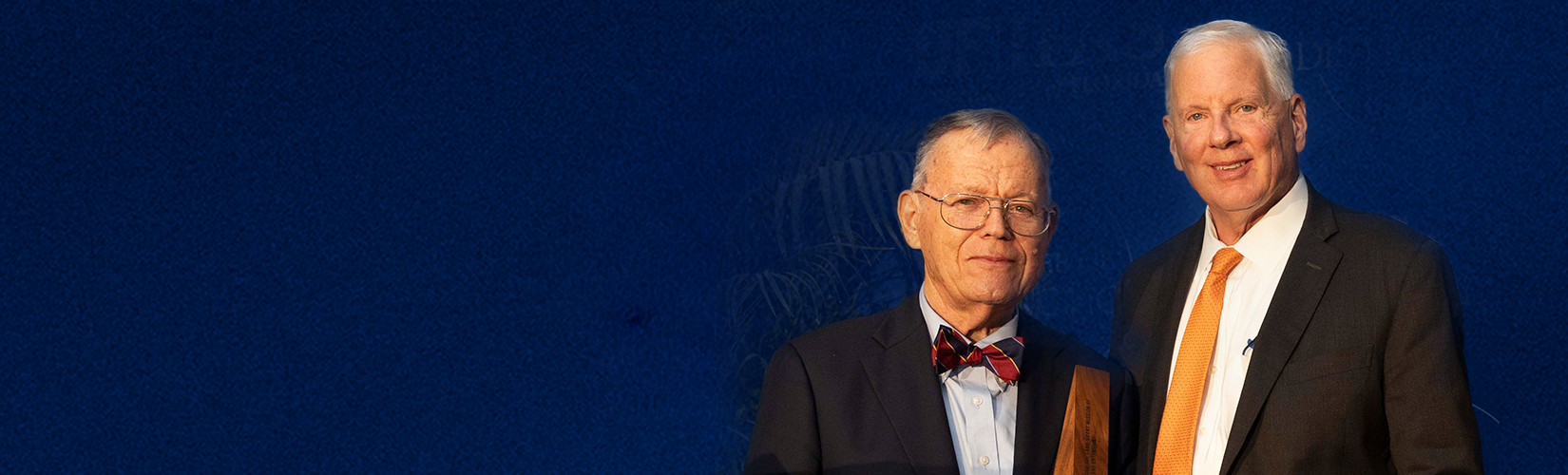 Erny Sellers and Scott Angle before a dark blue background